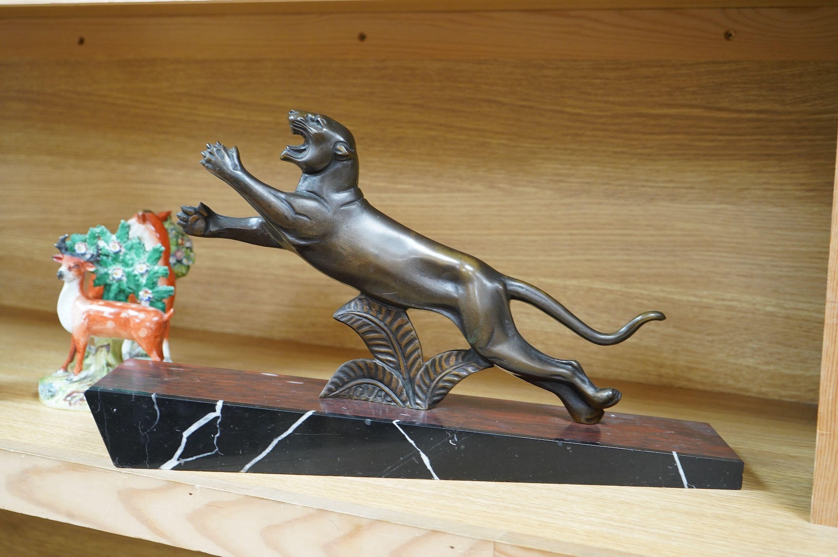 A French Art Deco bronze sculpture of a panther, raised on slanted base, 44cm wide